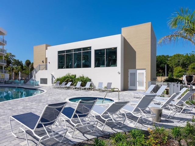 pool featuring stairs, a patio, a community hot tub, and fence