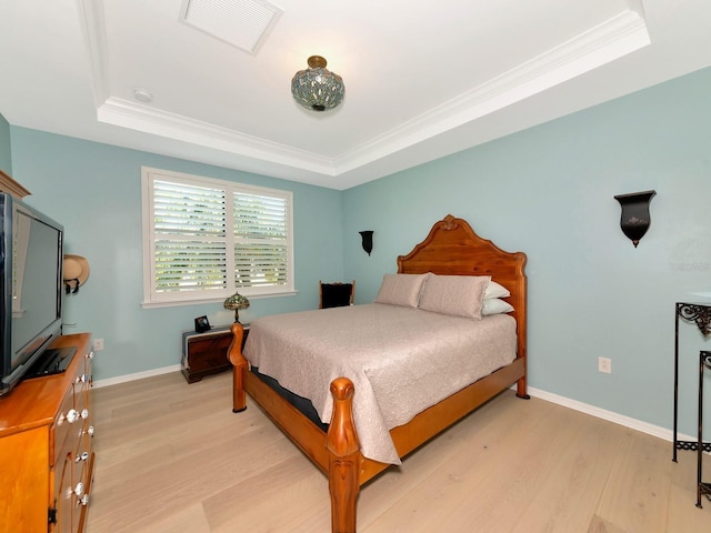 5952 Snowy Egret Dr, Sarasota, FL 34238 - bedroom with visible vents, a tray ceiling, ornamental molding, and light wood-style flooring