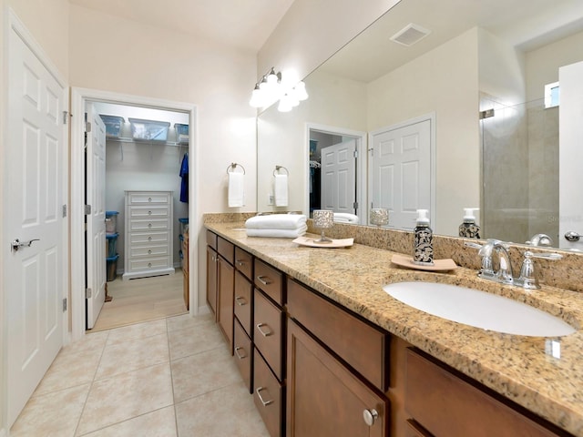 5952 Snowy Egret Dr, Sarasota, FL 34238 - full bathroom with double vanity, a spacious closet, tile patterned flooring, visible vents, and a sink