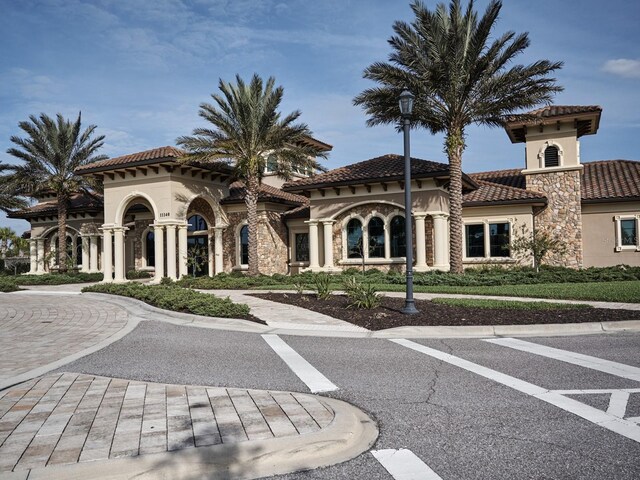 5952 Snowy Egret Dr, Sarasota, FL 34238 - mediterranean / spanish-style house featuring stucco siding, stone siding, and a tile roof