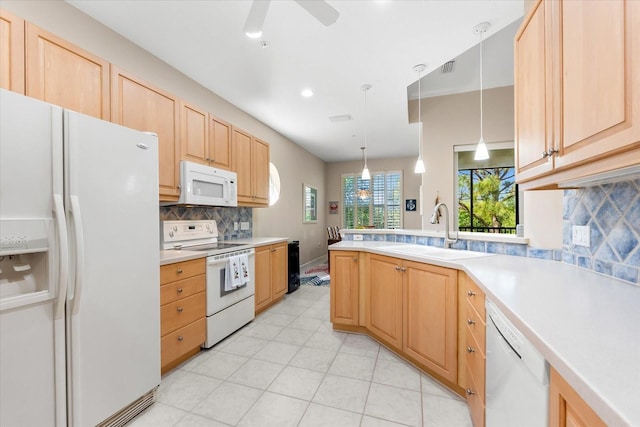 kitchen with a sink, backsplash, white appliances, and light brown cabinetry