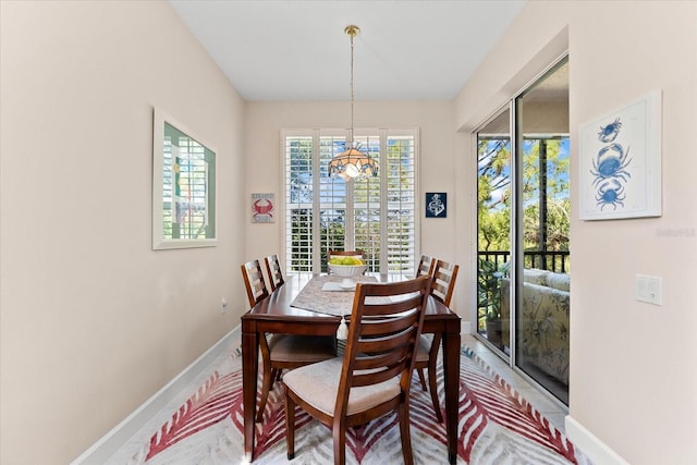 dining room featuring an inviting chandelier and baseboards