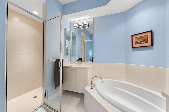 full bathroom featuring vanity, a stall shower, tile patterned flooring, and a garden tub