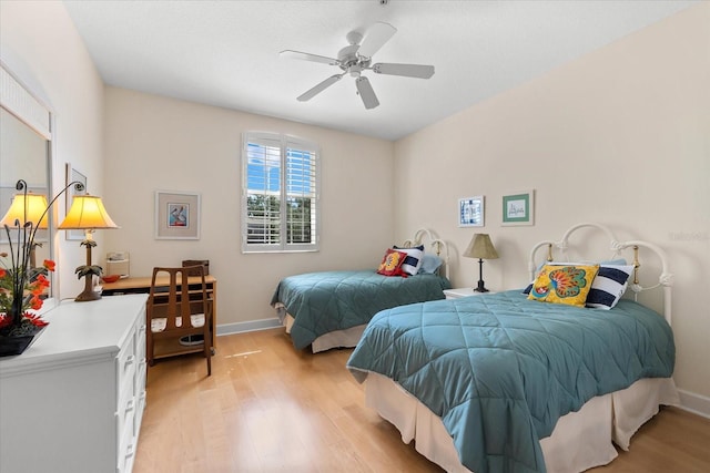 bedroom with baseboards, light wood-type flooring, and a ceiling fan