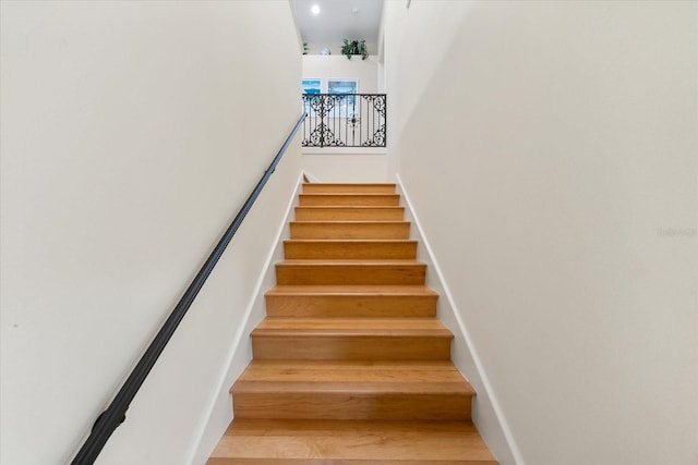 stairs with a towering ceiling and baseboards