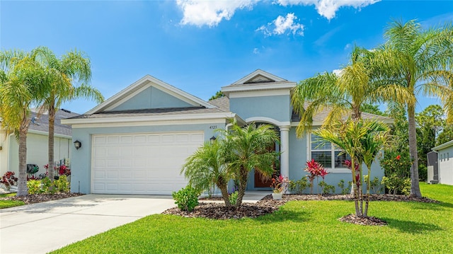 4325 Renwick Dr, Parrish, FL 34219 - ranch-style house featuring stucco siding, concrete driveway, a front yard, and an attached garage