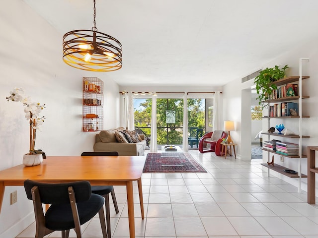 dining area with light tile patterned floors, baseboards, and an inviting chandelier