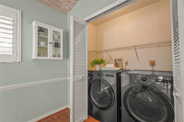 laundry area with washer and dryer, laundry area, baseboards, and wood finished floors