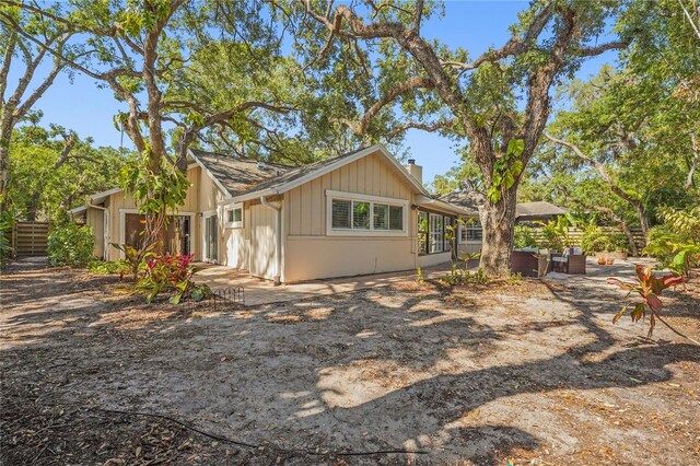 rear view of property featuring fence, a patio, and a chimney