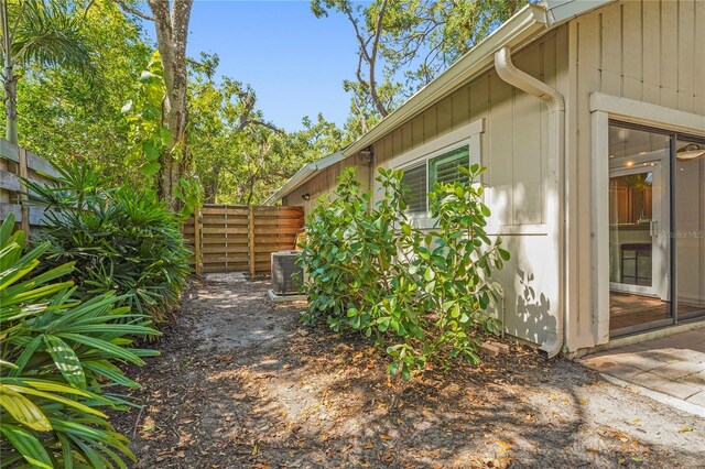 view of side of home featuring fence and cooling unit