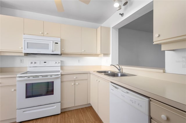 4570 Pinebrook Cir Unit 406, Bradenton, FL 34209 - kitchen featuring light wood-type flooring, a sink, light countertops, white appliances, and cream cabinetry