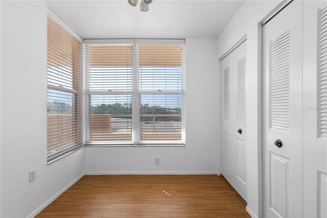 4570 Pinebrook Cir Unit 406, Bradenton, FL 34209 - unfurnished bedroom with baseboards, multiple windows, two closets, and wood finished floors