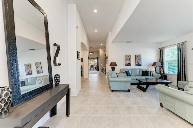 living area with baseboards, recessed lighting, light tile patterned floors, visible vents, and arched walkways