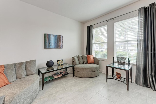 living area with light tile patterned floors and baseboards