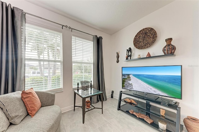living room featuring light tile patterned floors and baseboards