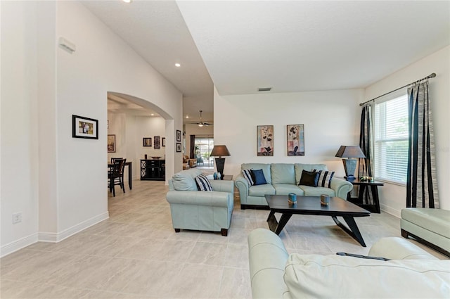 living area with arched walkways, a ceiling fan, visible vents, recessed lighting, and baseboards