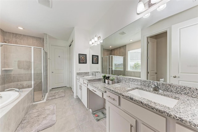bathroom featuring a bath, a stall shower, a sink, and visible vents