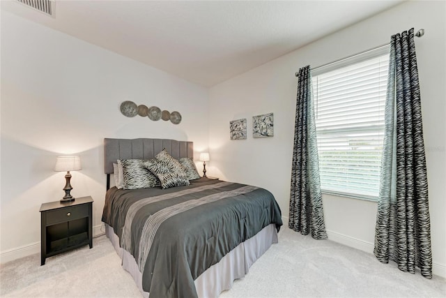 carpeted bedroom with visible vents and baseboards
