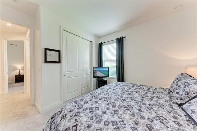 carpeted bedroom featuring a closet and baseboards