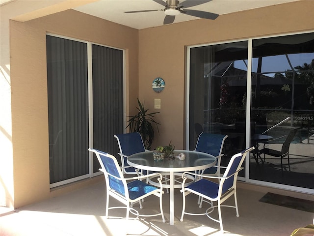 view of patio / terrace featuring a lanai, a ceiling fan, and outdoor dining area