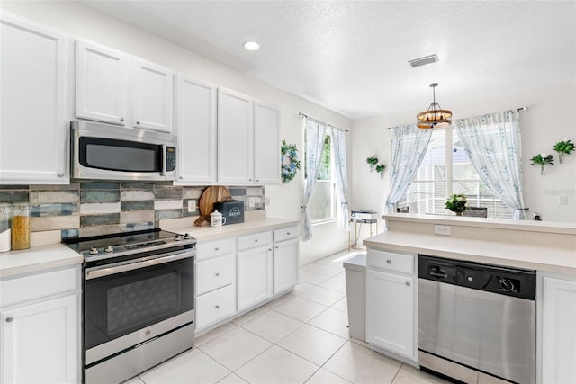 kitchen featuring light countertops, appliances with stainless steel finishes, tasteful backsplash, and white cabinetry