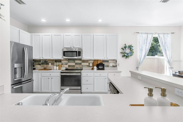 kitchen featuring light countertops, white cabinets, stainless steel appliances, and a sink