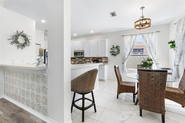 dining area featuring recessed lighting, baseboards, visible vents, and an inviting chandelier