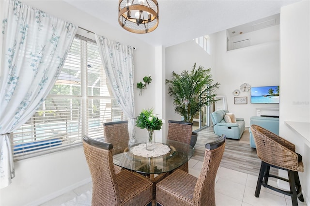 dining space featuring baseboards, a chandelier, and light tile patterned floors
