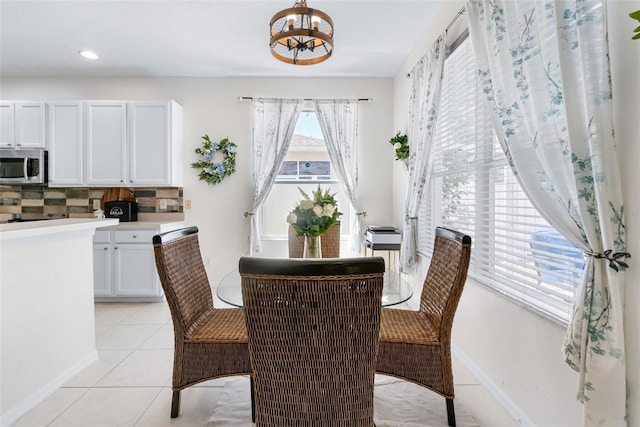 dining area with an inviting chandelier, light tile patterned floors, baseboards, and recessed lighting
