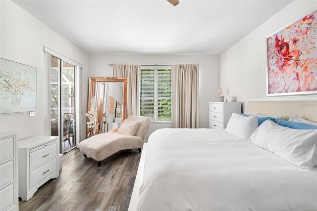 bedroom with access to outside and wood finished floors