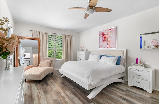 bedroom featuring ceiling fan, baseboards, and light wood finished floors