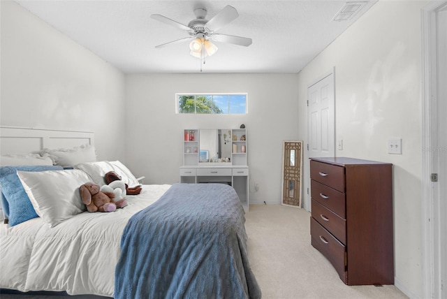 bedroom with light colored carpet, a ceiling fan, and visible vents