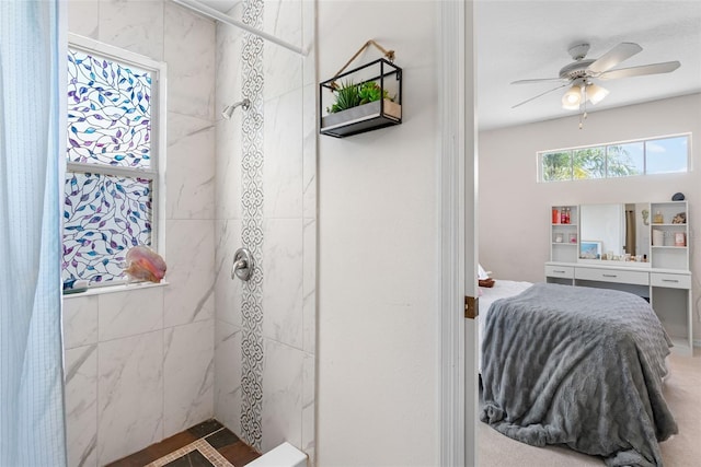 bathroom with ceiling fan and tiled shower