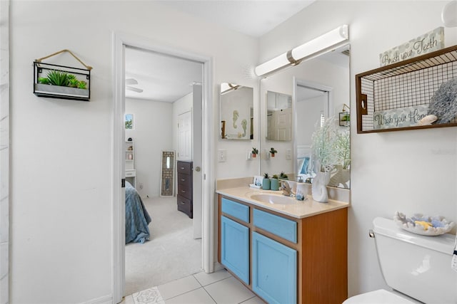 bathroom featuring toilet, ensuite bathroom, tile patterned flooring, and vanity