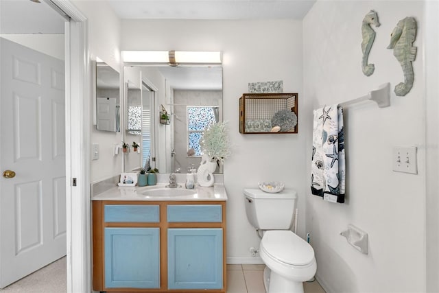 bathroom with tile patterned flooring, curtained shower, vanity, baseboards, and toilet