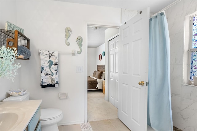ensuite bathroom featuring vanity, toilet, connected bathroom, tile patterned floors, and a shower with curtain