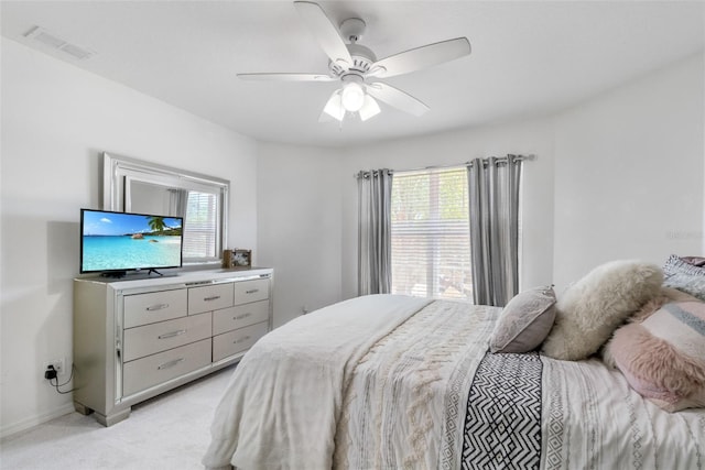 bedroom featuring multiple windows, light carpet, ceiling fan, and visible vents