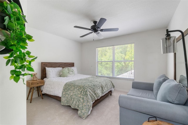 bedroom with baseboards, ceiling fan, and light carpet
