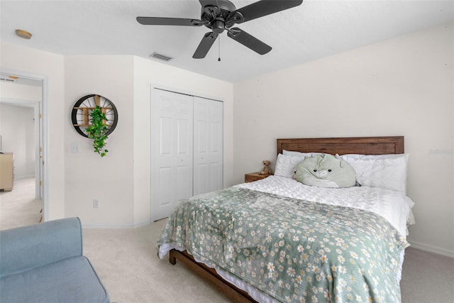 carpeted bedroom with a ceiling fan, baseboards, visible vents, and a closet
