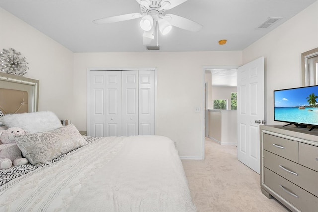 bedroom with a closet, baseboards, light colored carpet, and visible vents