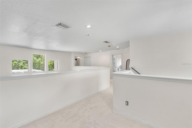 empty room featuring visible vents, recessed lighting, baseboards, and light colored carpet