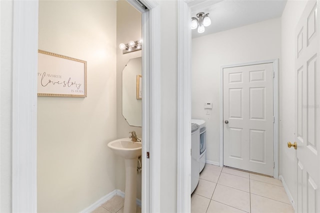 bathroom featuring separate washer and dryer, tile patterned floors, and baseboards