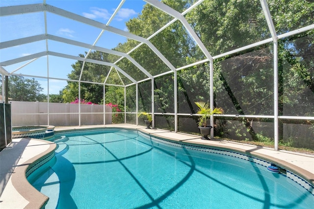 view of pool with a pool with connected hot tub and a lanai