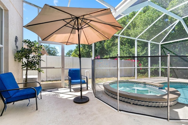 view of patio with glass enclosure, a pool with connected hot tub, and a fenced backyard