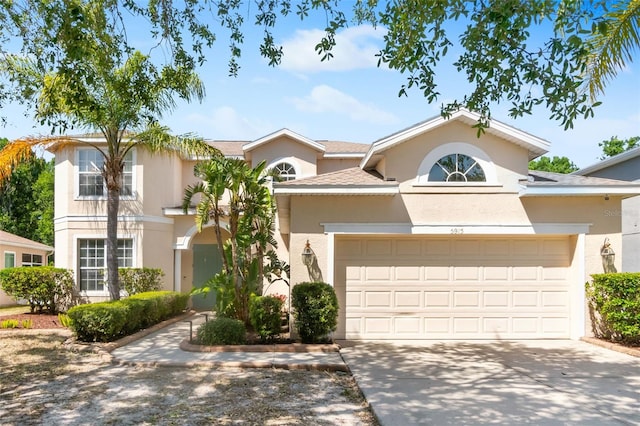 view of front of home featuring an attached garage, driveway, and stucco siding