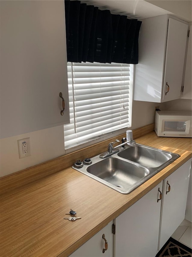 4502 3rd Street Cir W Unit 242, Bradenton, FL 34207 - kitchen with light countertops, white microwave, white cabinets, and a sink