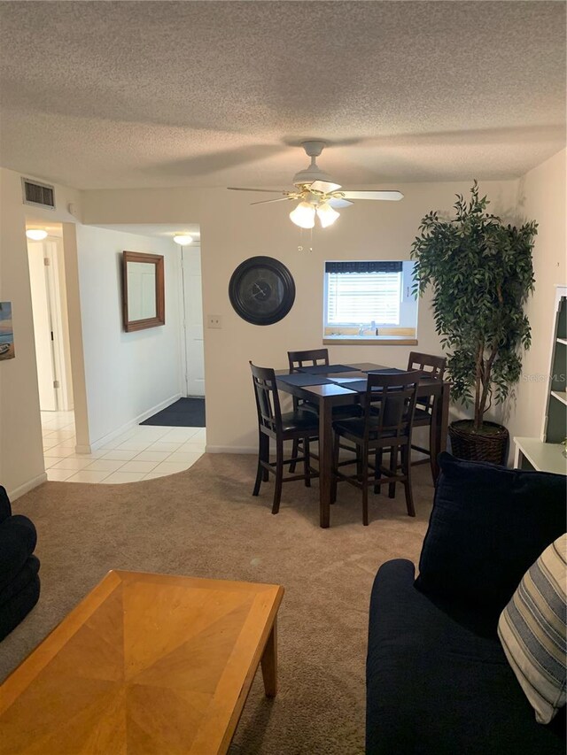 4502 3rd Street Cir W Unit 242, Bradenton, FL 34207 - dining space featuring light tile patterned floors, a textured ceiling, visible vents, ceiling fan, and light colored carpet