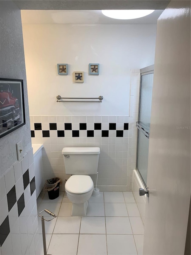 4502 3rd Street Cir W Unit 242, Bradenton, FL 34207 - full bathroom featuring toilet, enclosed tub / shower combo, a wainscoted wall, tile walls, and tile patterned flooring