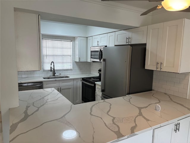 kitchen with a sink, crown molding, stainless steel appliances, and tasteful backsplash