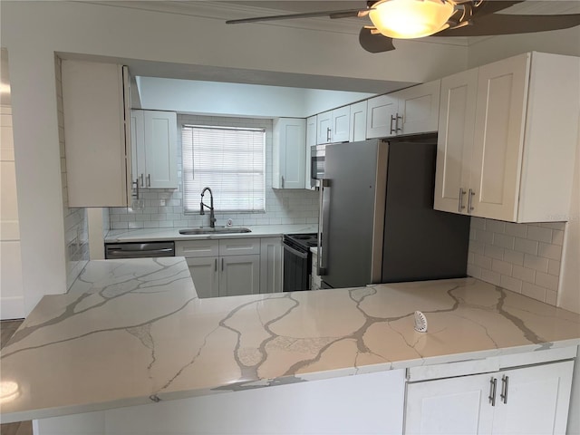 kitchen with a sink, freestanding refrigerator, black electric range, light stone countertops, and tasteful backsplash